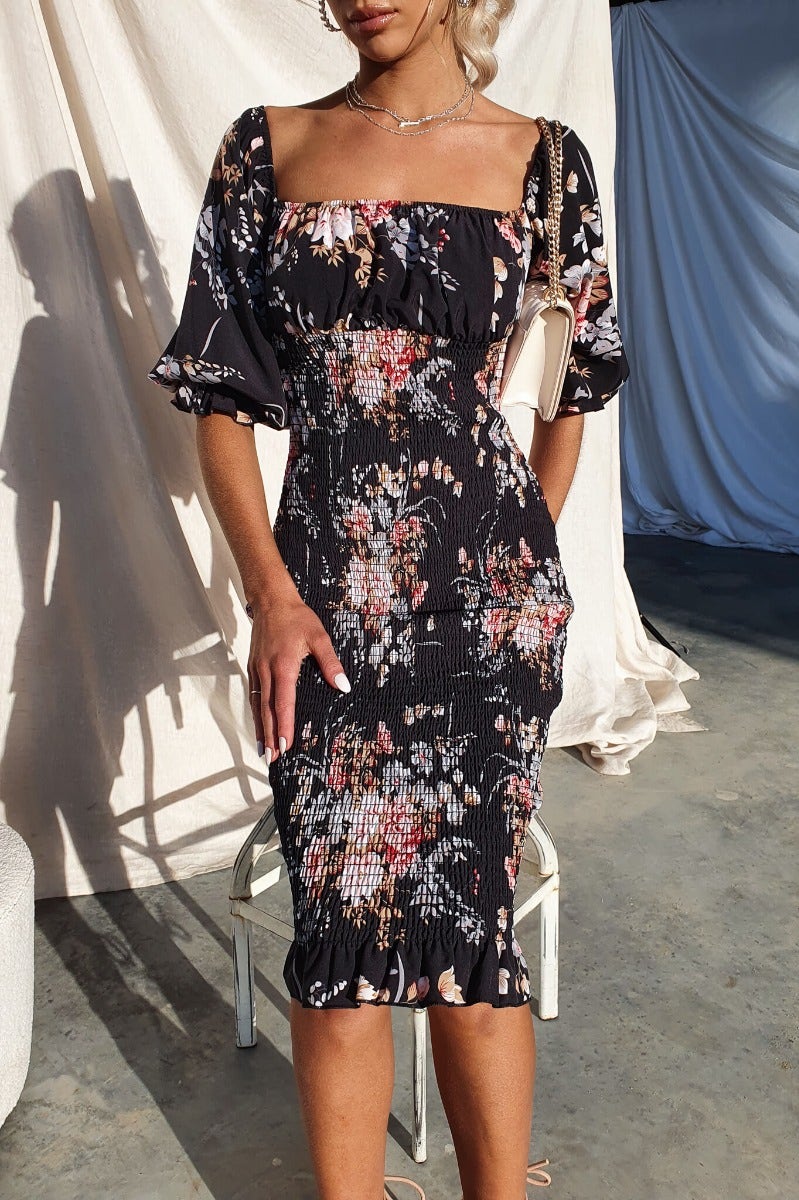 Arabella Midi Dress in floral print, featuring elastic neckline and sleeves, worn by model in casual setting.