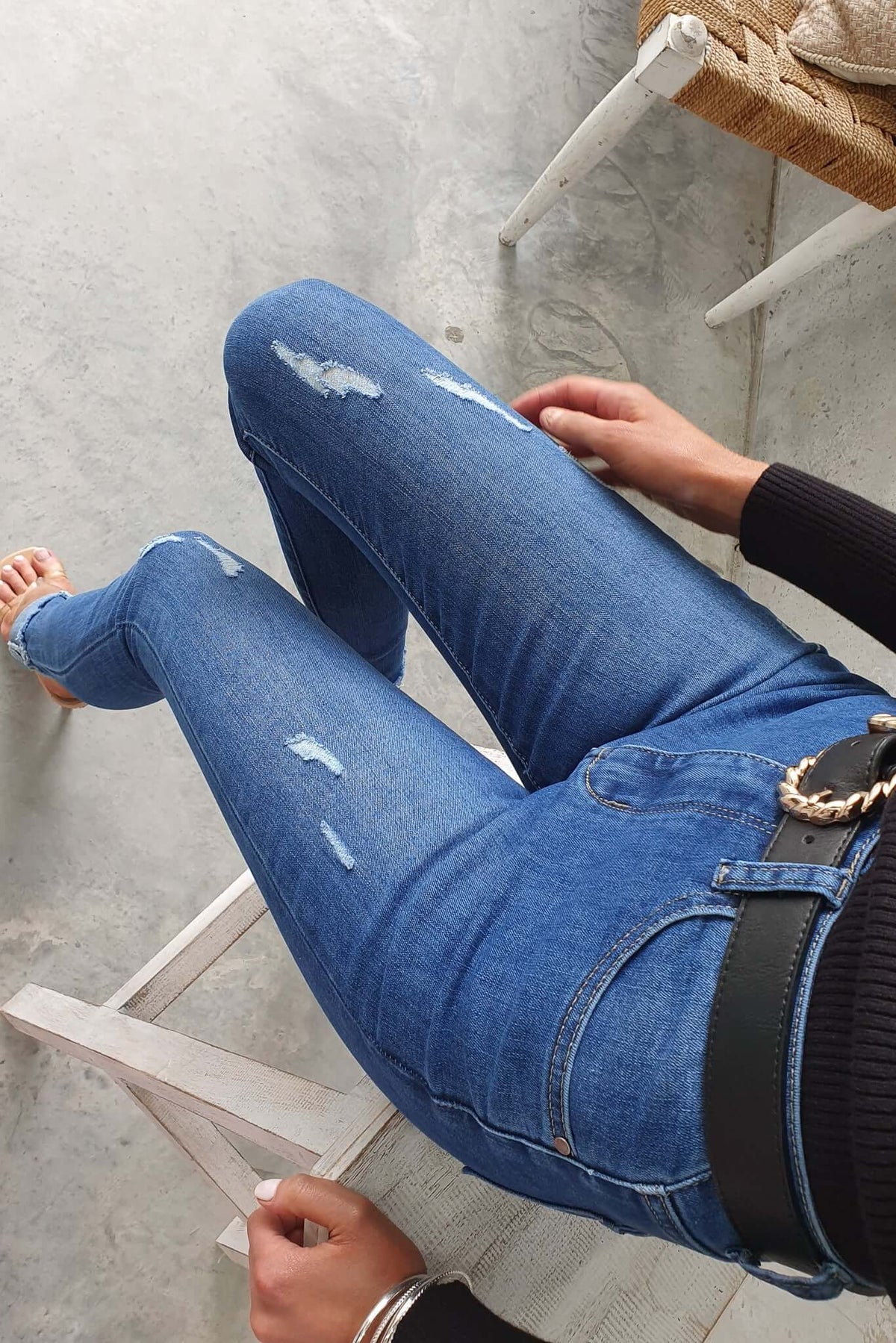 Model wearing distressed Lettie jeans with mid-high waist, front and back pockets, showcasing stylish denim fashion.