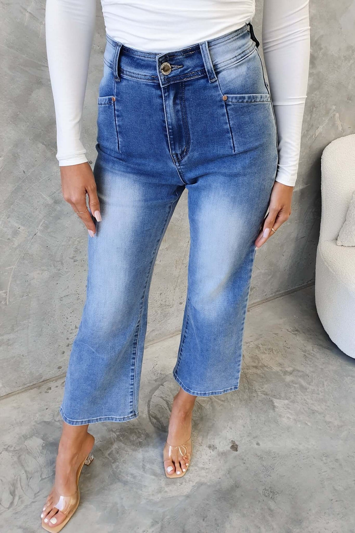 Blanca Jeans featuring a mid-high waist fit, wide legs, and a distressed look, styled with clear sandals.