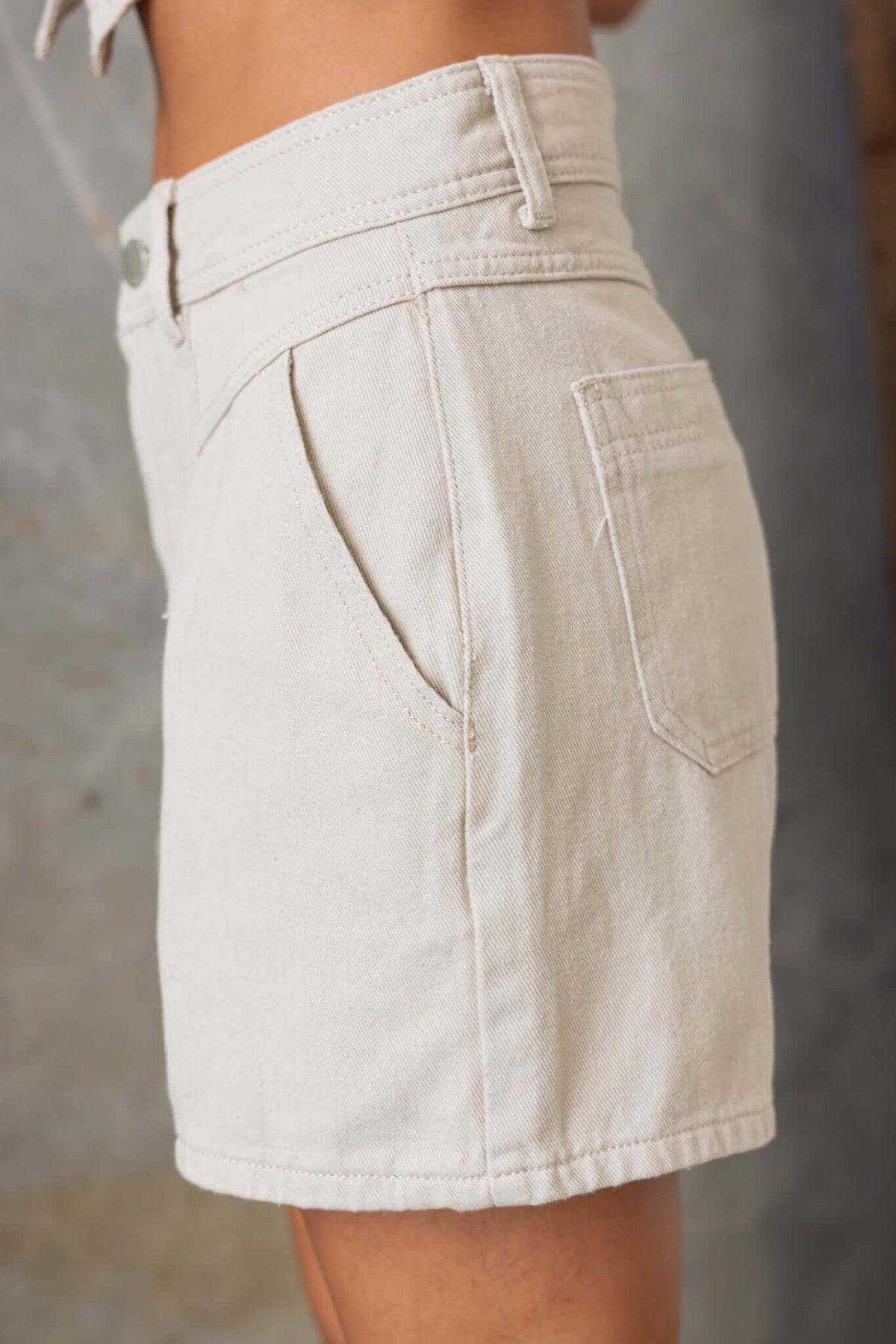 Profile view of Tampa denim shorts featuring mid-high waist and pockets, made from 100% cotton.
