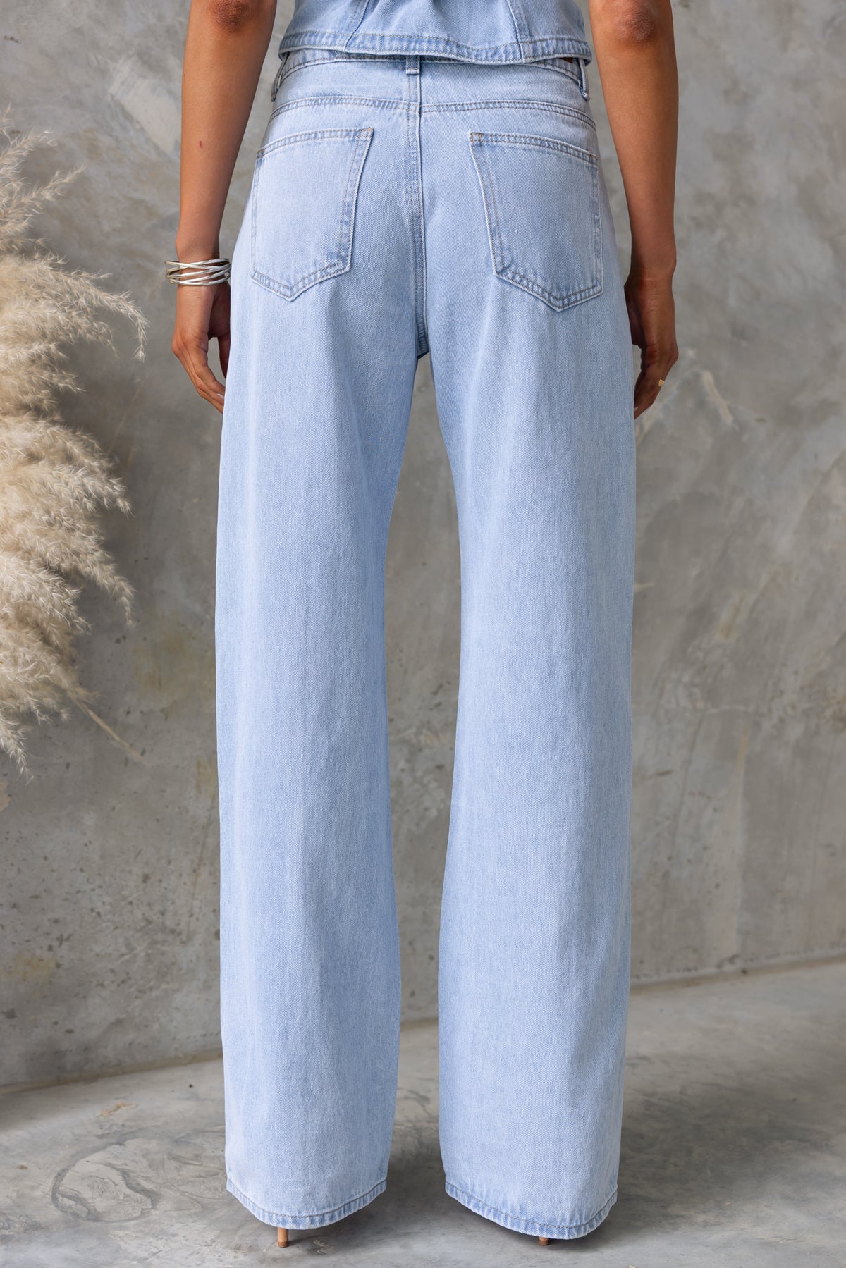 Back view of Billie Jeans featuring wide legs and mid-high waist design in light blue denim.