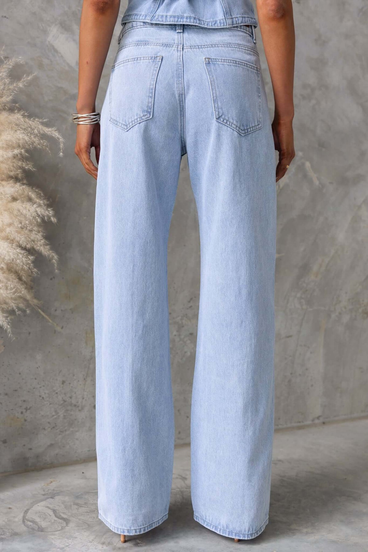 Back view of Billie Jeans featuring wide legs and mid-high waist design in light blue denim.