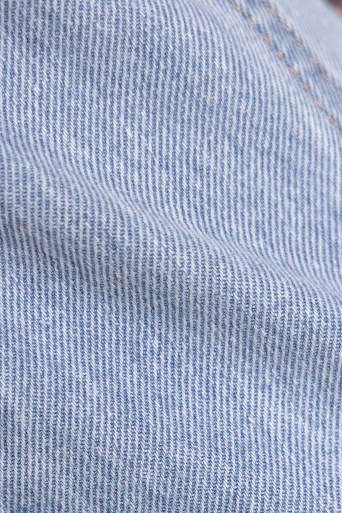 Close-up of denim fabric showing texture for Billie jeans, featuring mid-high waist and wide legs.