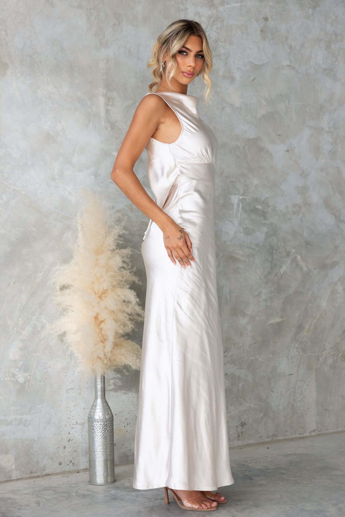 Silvia Maxi Dress featuring a boat neckline and elegant satin draping, styled with a tied back.