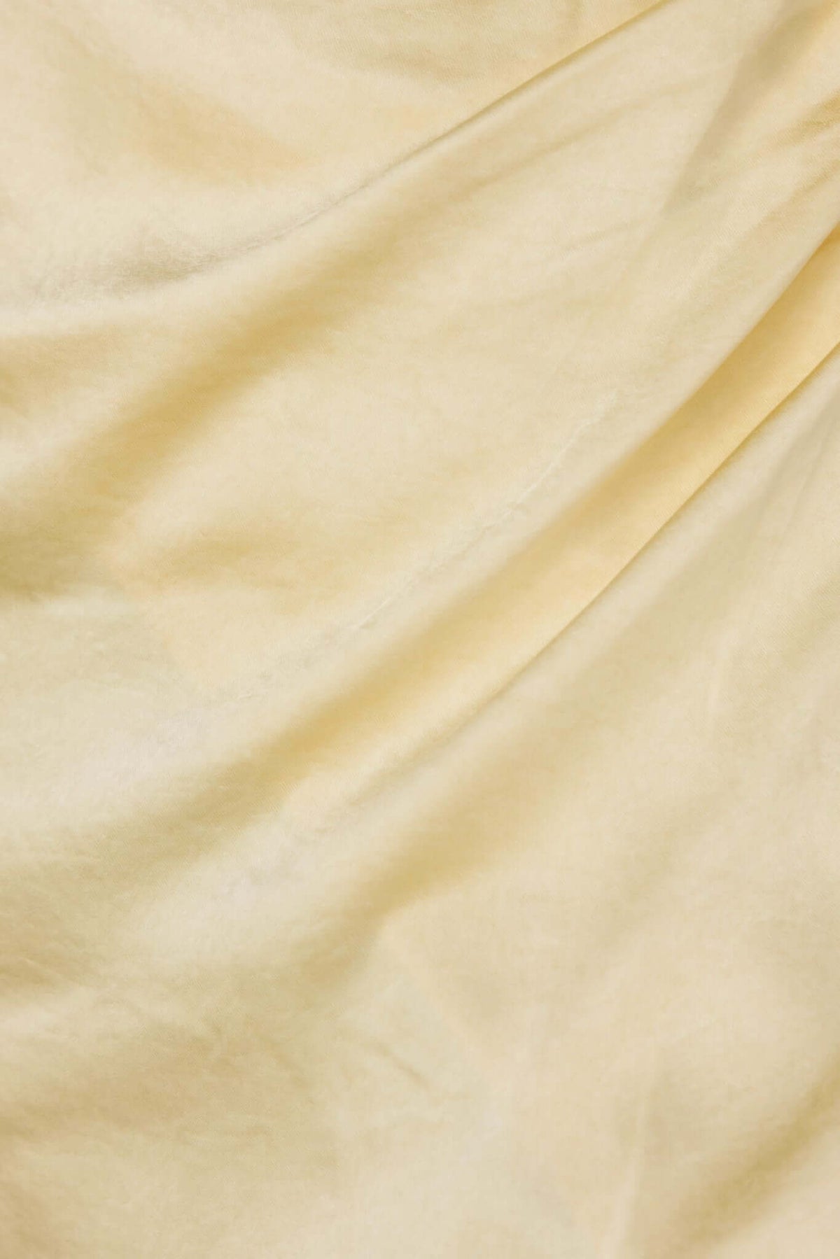Soft, draped fabric in a light yellow color, showcasing texture and movement for the Merritt Maxi Dress.