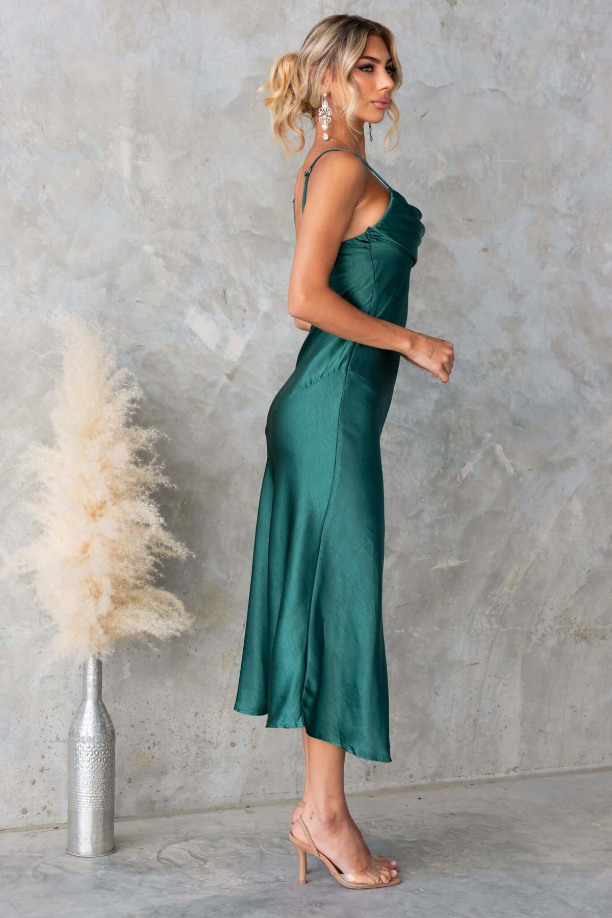 Model showcasing the Brighton Midi Dress in green satin, featuring adjustable straps and a front split.