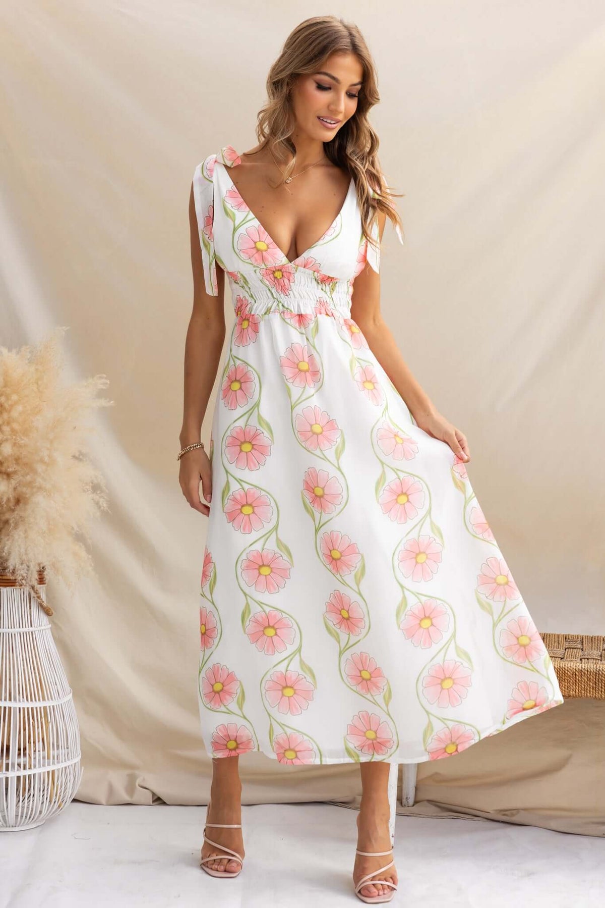 Model wearing the Torrance Maxi Dress with floral design, featuring adjustable ties and a flowing silhouette.
