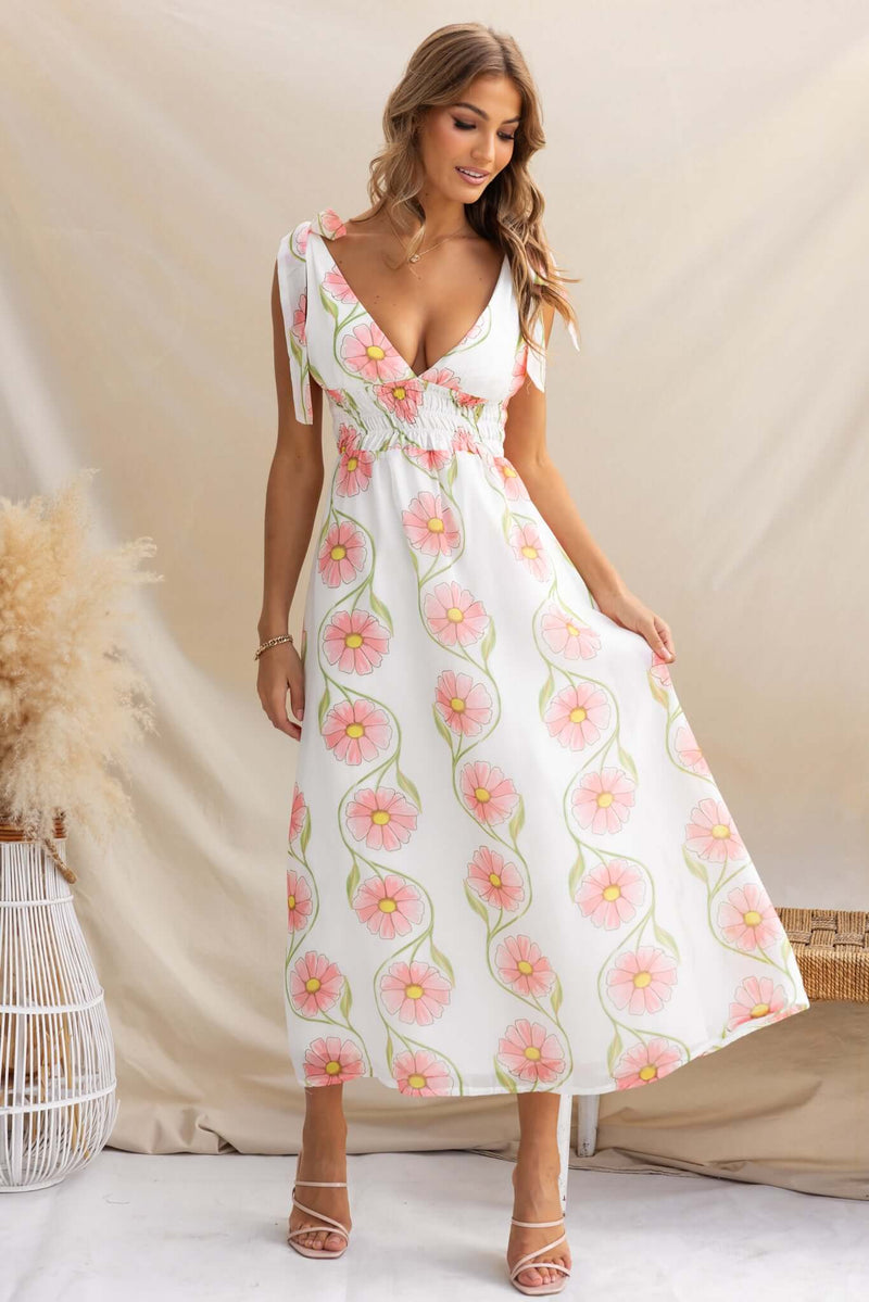 Model wearing the Torrance Maxi Dress with floral design, featuring adjustable ties and a flowing silhouette.