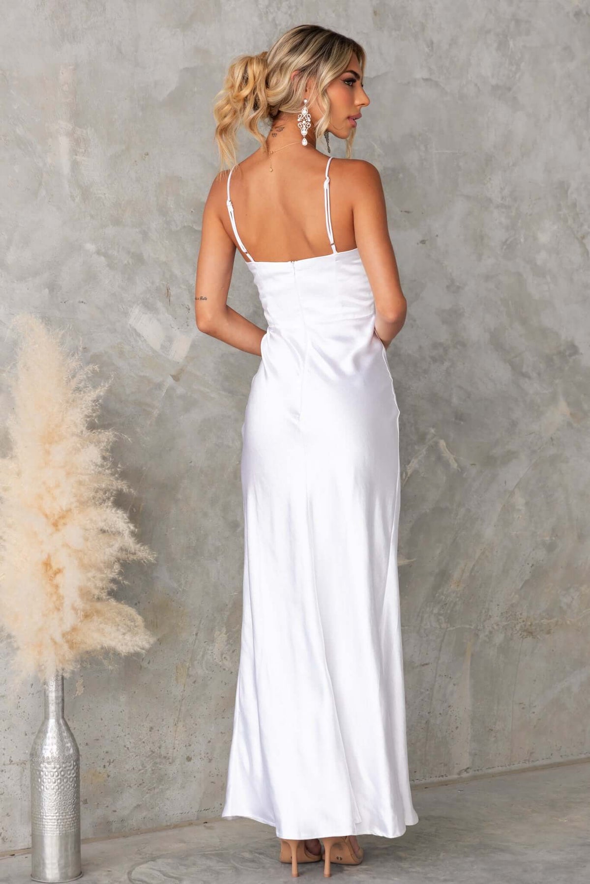 Back view of the Maricia Maxi Dress, a sleek white gown with adjustable straps and elegant silhouette.