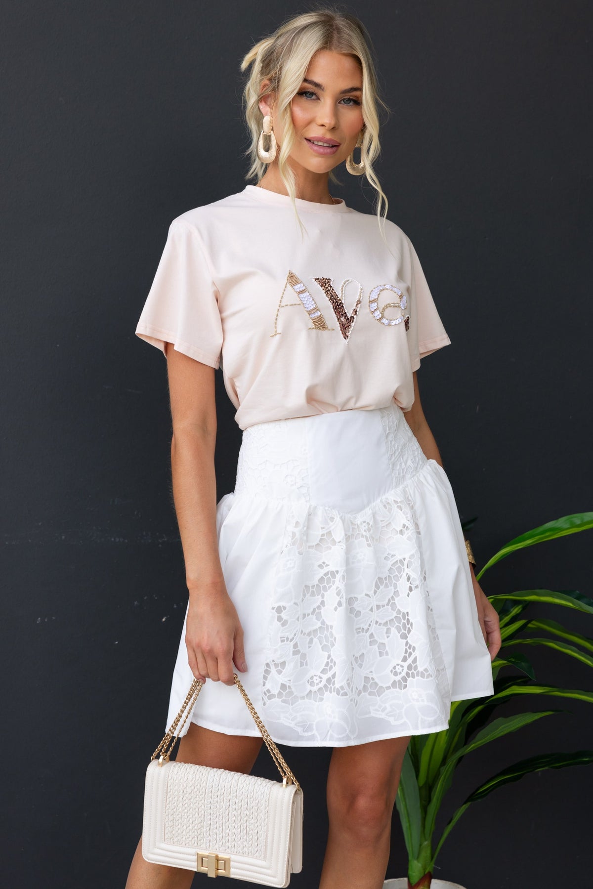 Model wearing a cotton blend fancy skirt with Anglasie detailing and a mid-high waist fit, paired with a casual top.