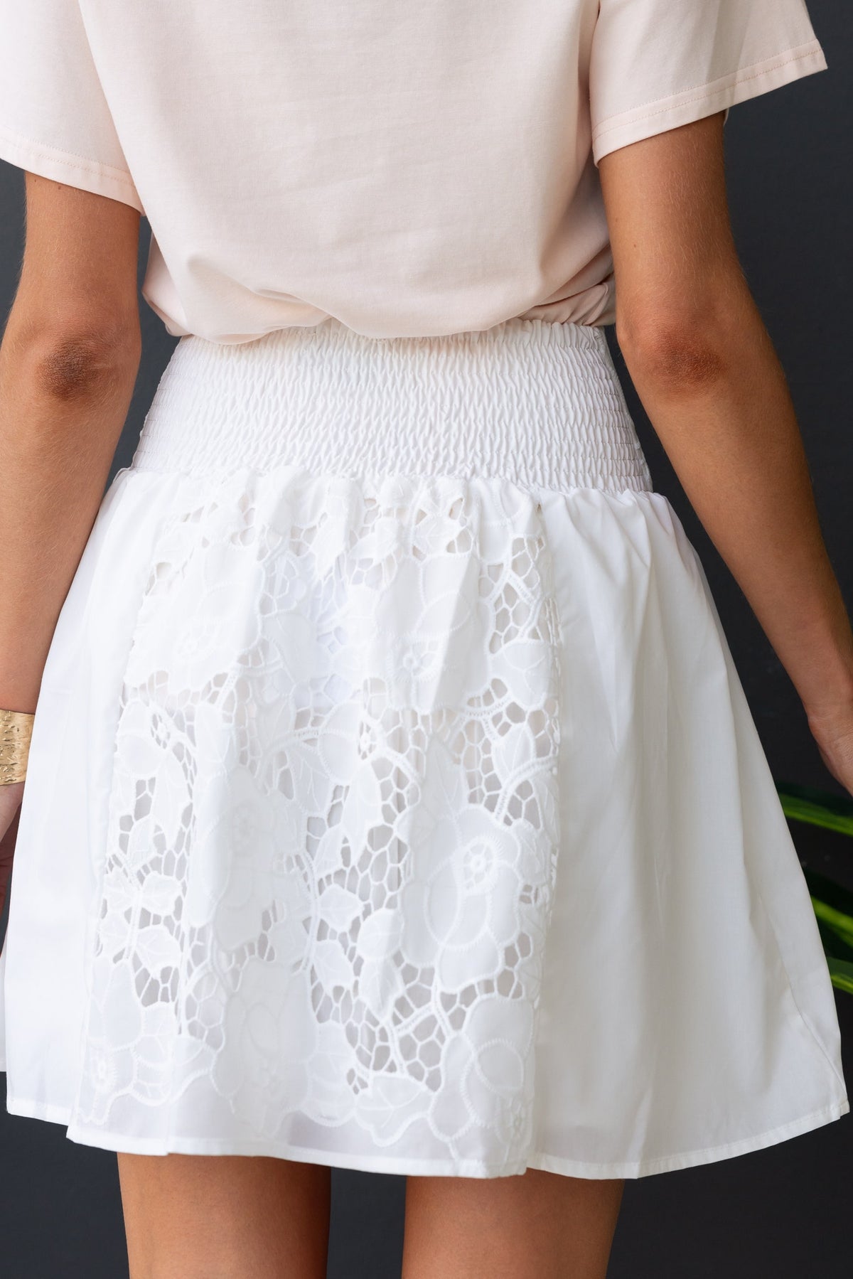 Back view of a white cotton blend skirt with Anglasie detailing, mid-high waist fit and elastic back.