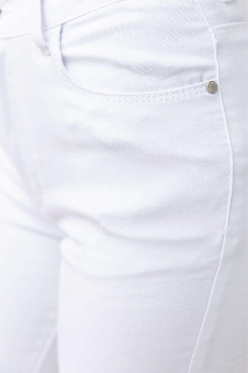 Close-up of Vaca Jeans featuring mid waist design and stretchable white denim fabric.
