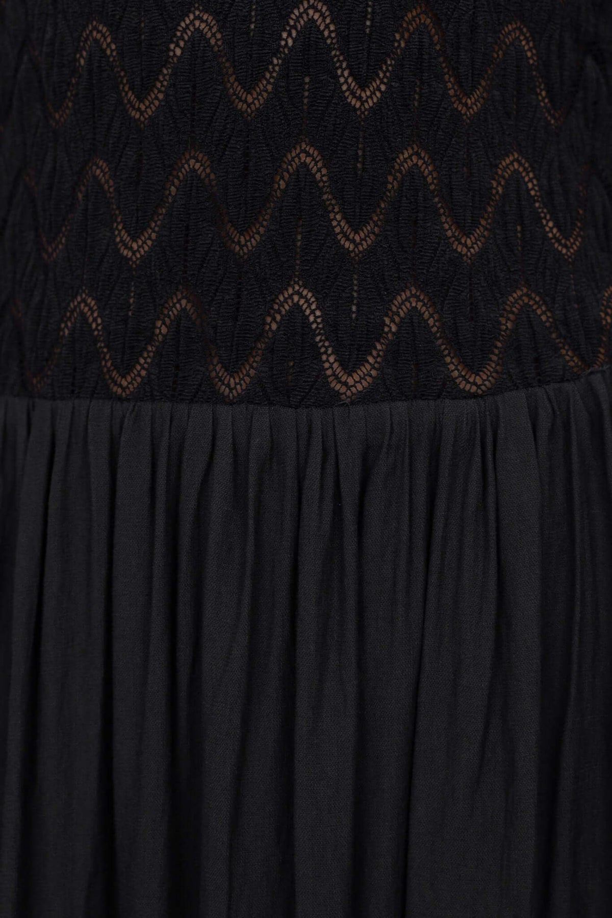 Close-up of Thaisa Maxi Dress featuring lace bodice and flowing black fabric, highlighting adjustable straps and detailed texture.