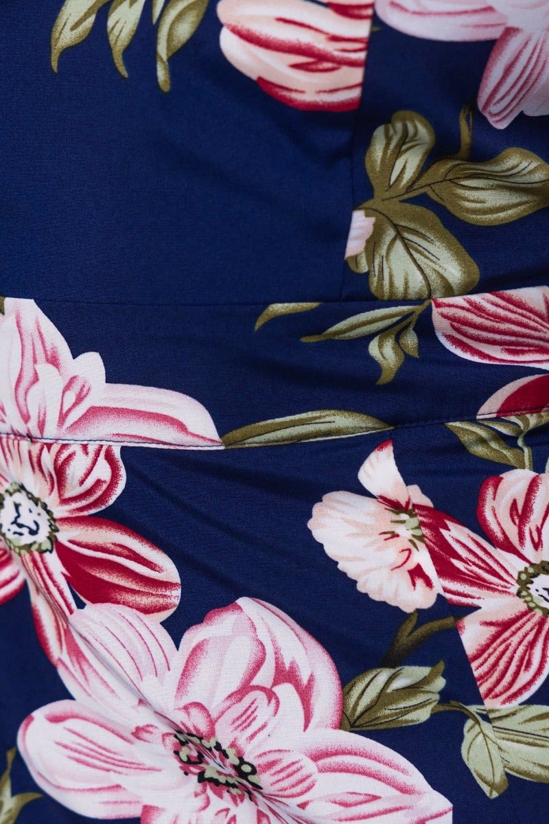 Close-up of navy floral print fabric on Flourish Midi Dress, featuring vibrant pink flowers and lush green leaves.
