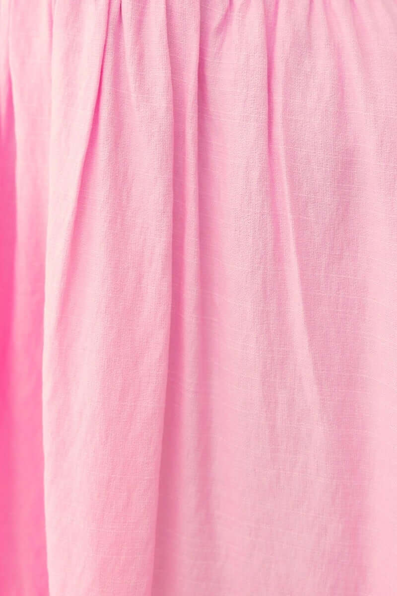 Close-up of the pink fabric of the Love In Motion Dress, showcasing its soft cotton blend texture and lightweight feel.