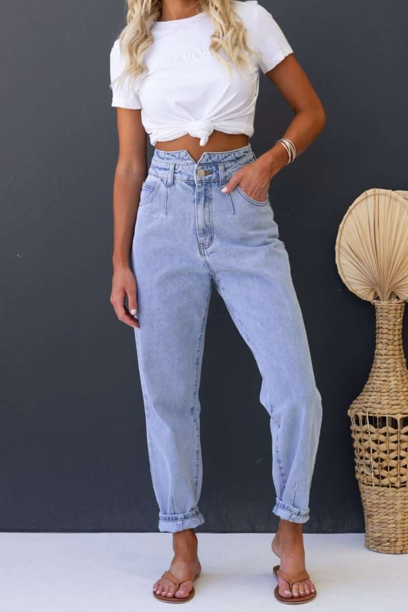 Shaylan Mom Jeans in light denim, mid-high waist, wide legs, front and back pockets, styled with a knotted white shirt.
