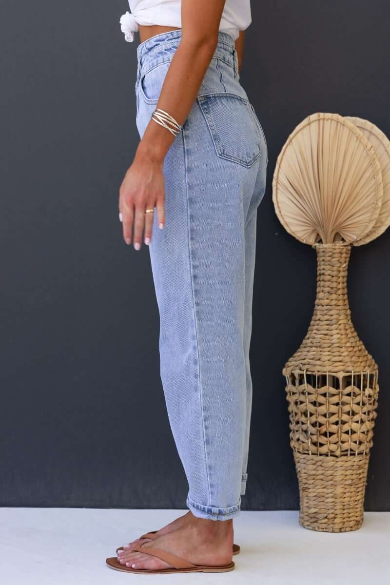 Model wearing Shaylan Mom Jeans in light wash, showcasing mid-high waist, wide leg design and pockets.