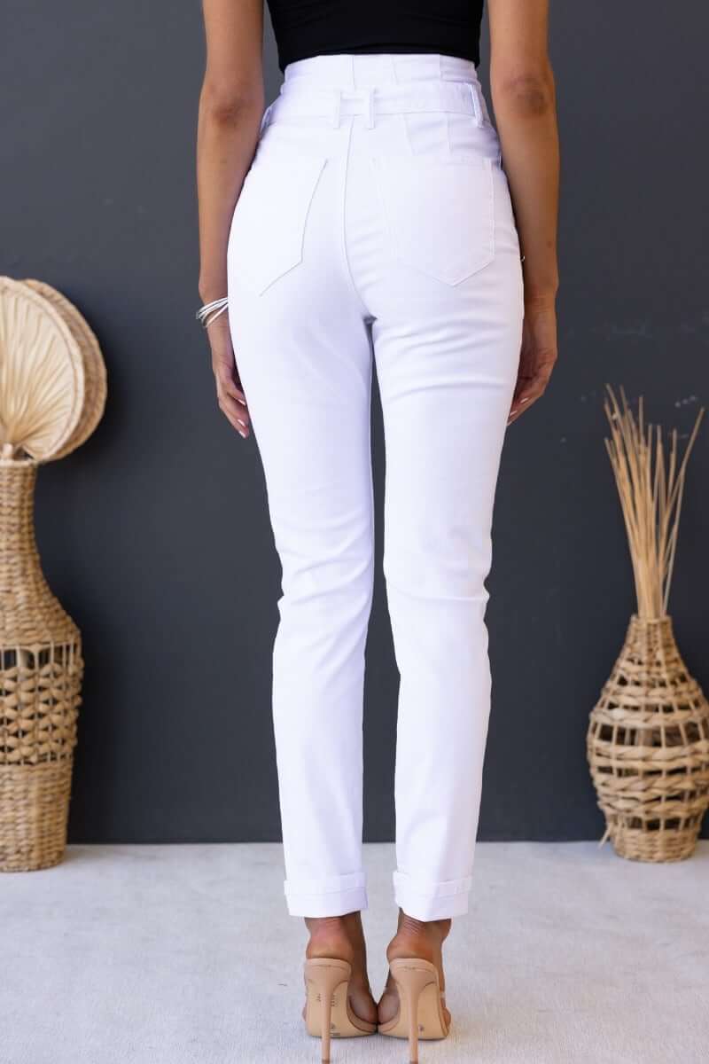 Back view of high waist white denim jeans on model, showcasing fitted design and minimalistic style.