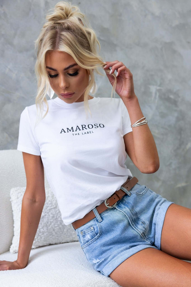 Model wearing Kim Denim Shorts with distressed detailing and a white Amaroso the Label tee.