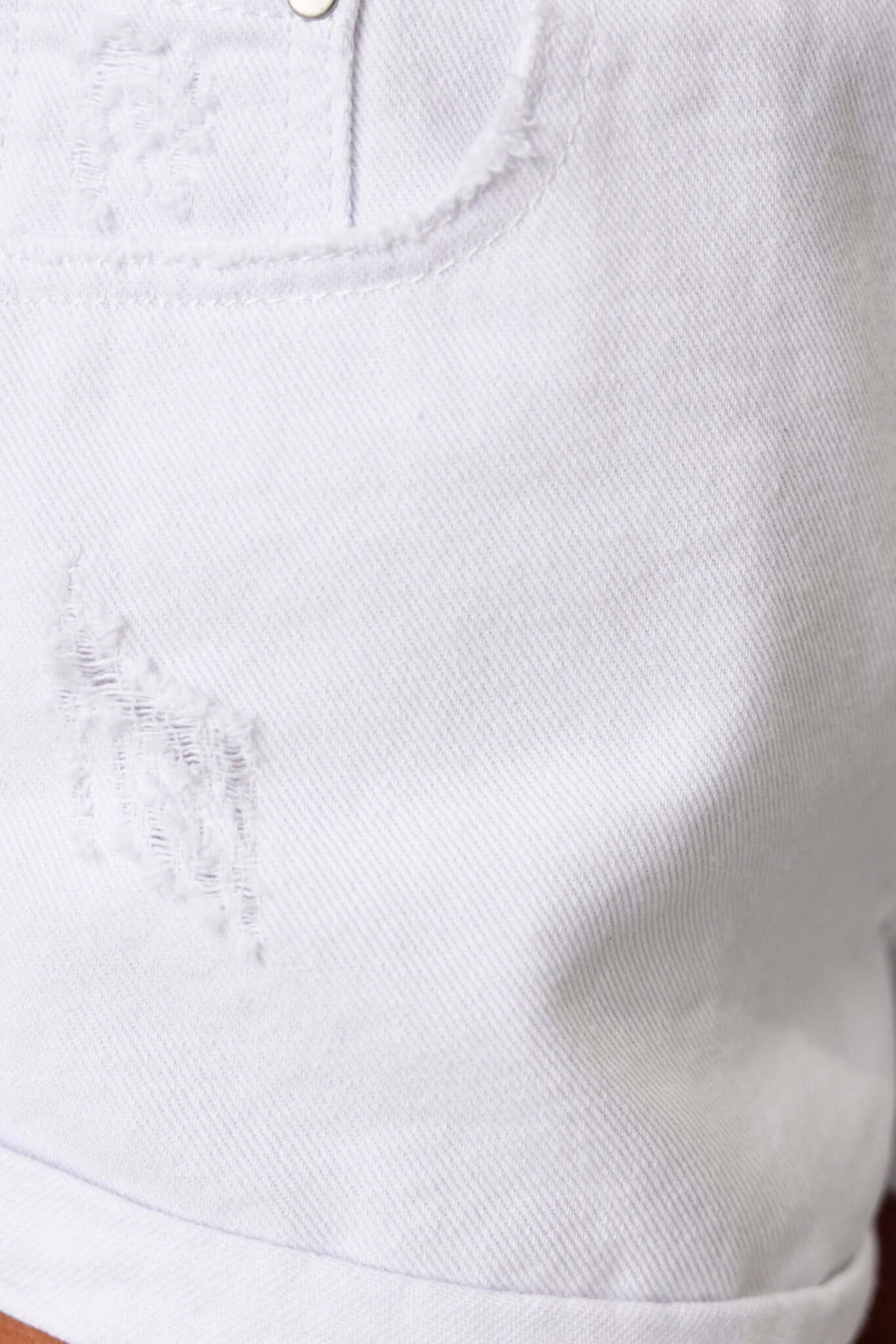 Close-up of Kim Denim Shorts featuring distressed detailing and pockets in a light wash.