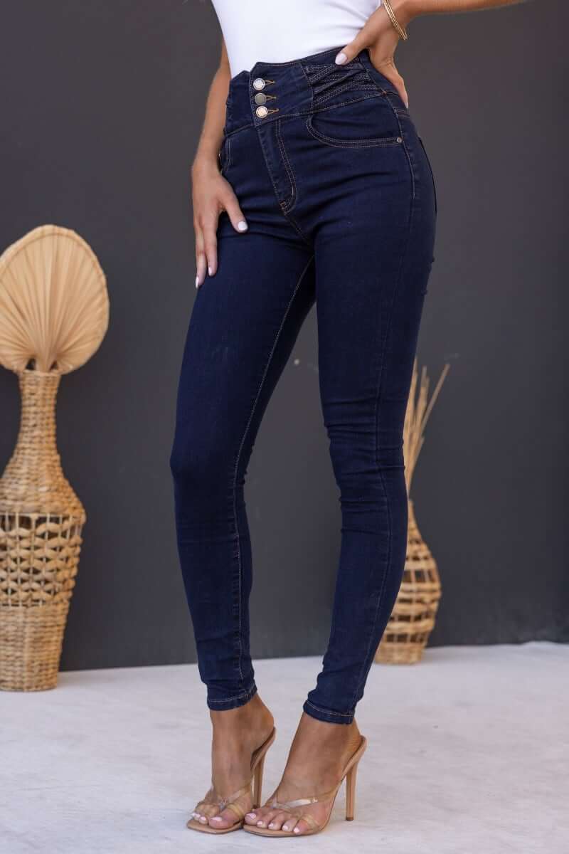 Model wearing Quiver Jeans, dark navy denim, mid-high waist with lattice detail and front pockets.