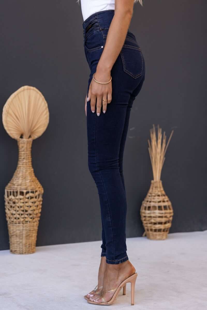 Side view of Quiver Jeans in dark navy denim showcasing mid-high waist fit and pockets.