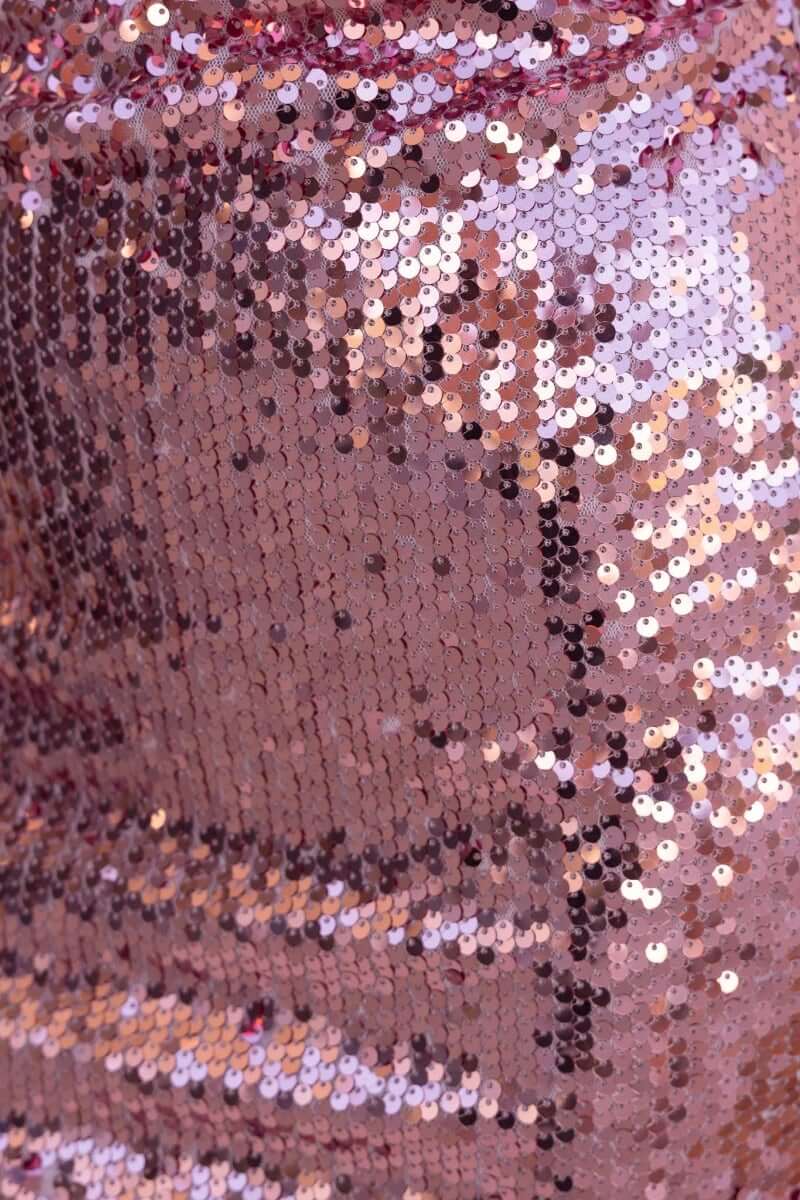 Close-up of rose gold sequins on Qordelia Dress, showcasing the shimmering texture and intricate detailing.