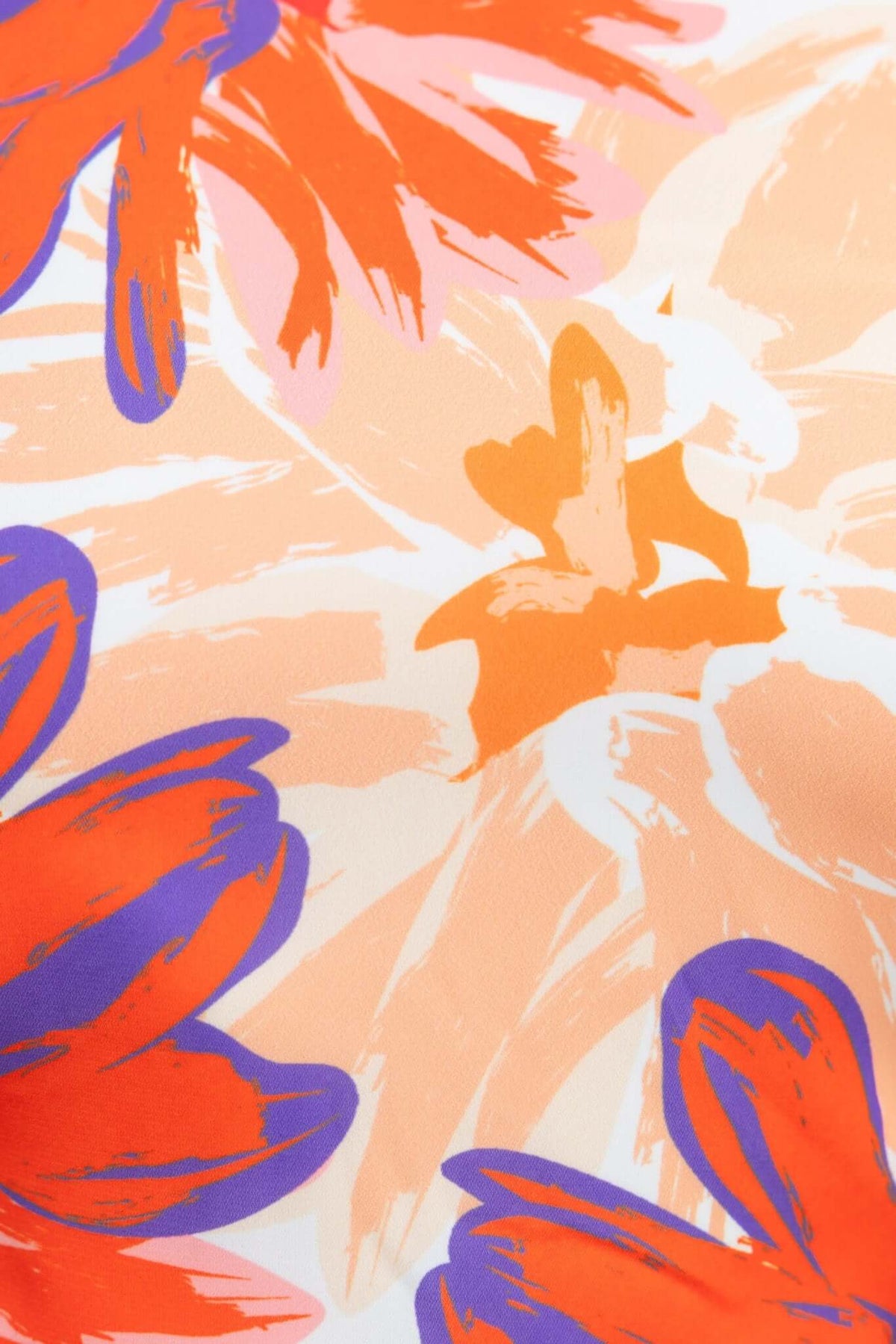 Close-up of vibrant floral pattern with red, orange, and purple colors on a soft background, perfect for fashion designs.
