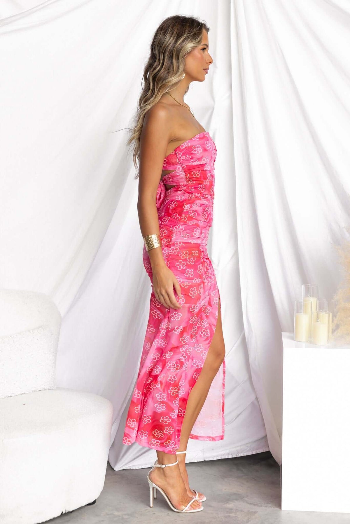 Model in a pink floral strapless midi dress with a side split, showcasing a stylish summer look.