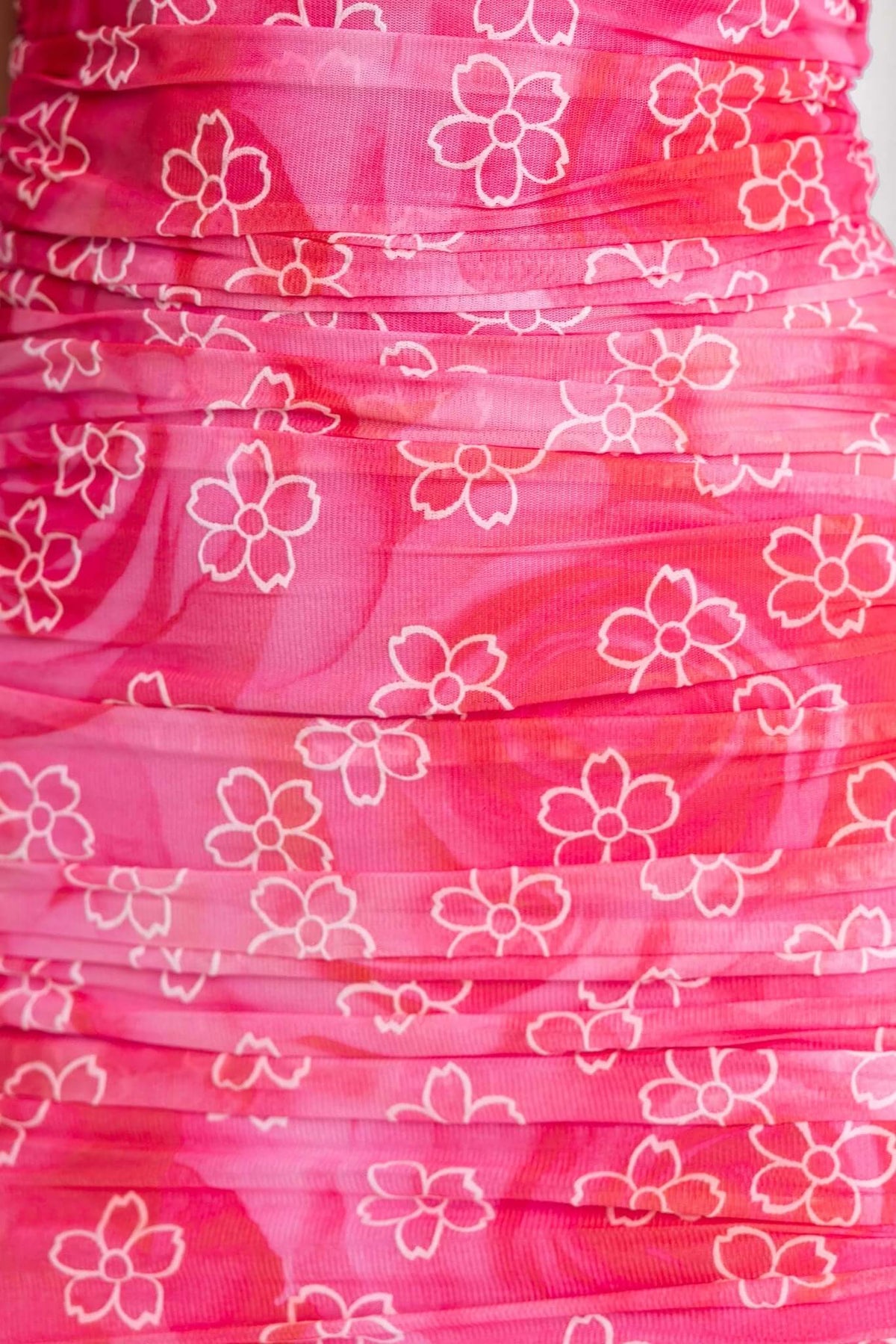 Close-up of Blomma Midi Dress featuring floral print in shades of pink with gathered fabric design.
