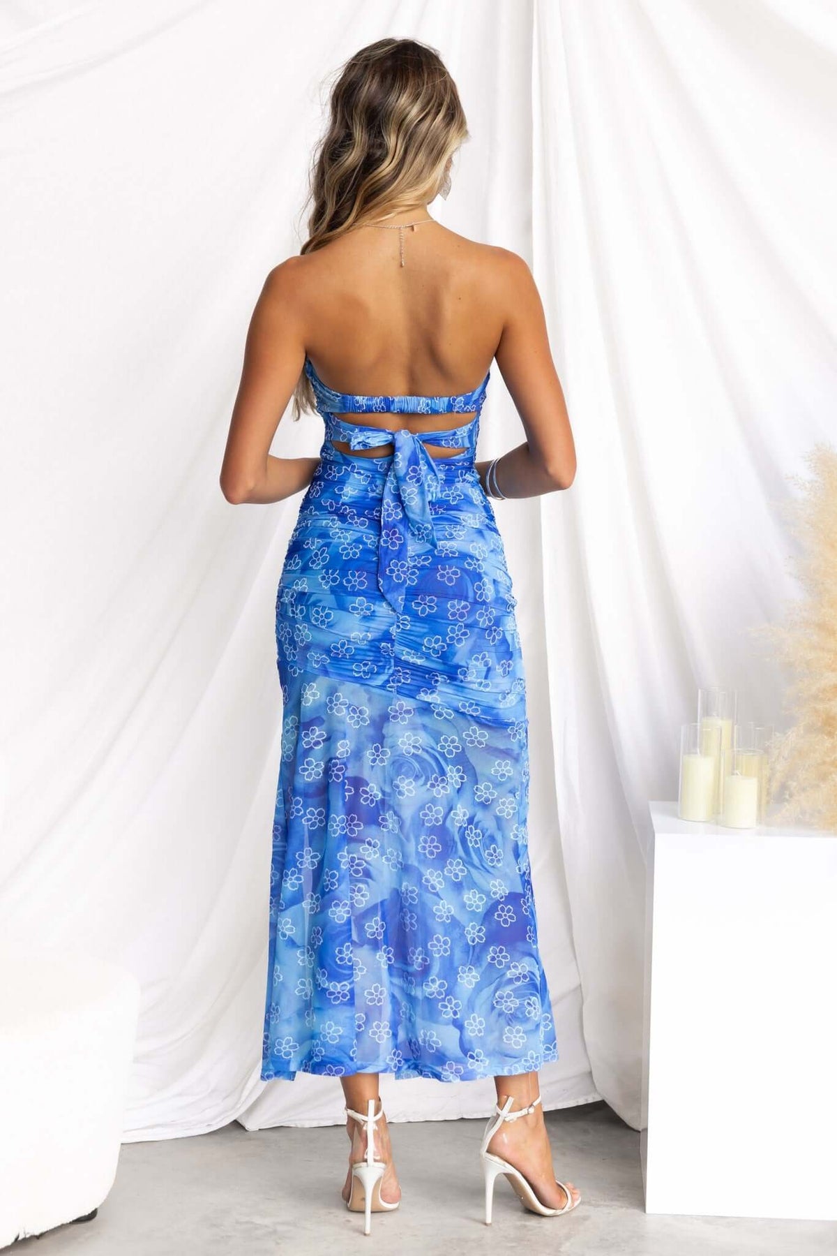Back view of the Blomma Midi Dress in blue with a strapless design and attached fabric tie.