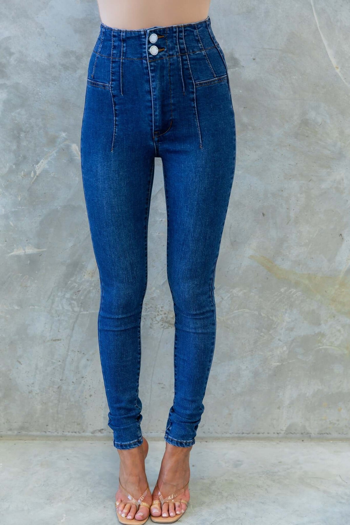 Okara Jeans high-waisted denim skinny fit with two-button closure and faux pockets. Firm stretch for comfort and style.
