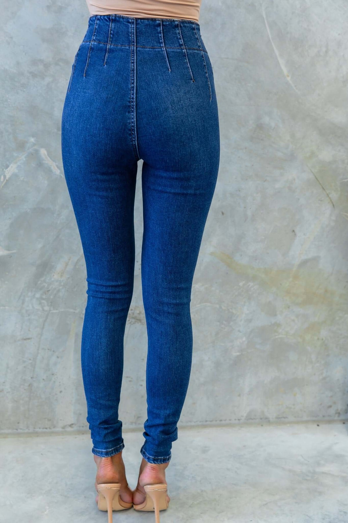 Rear view of mid-high waist Okara skinny jeans with two-button closure and firm stretch, ideal for a stylish look.