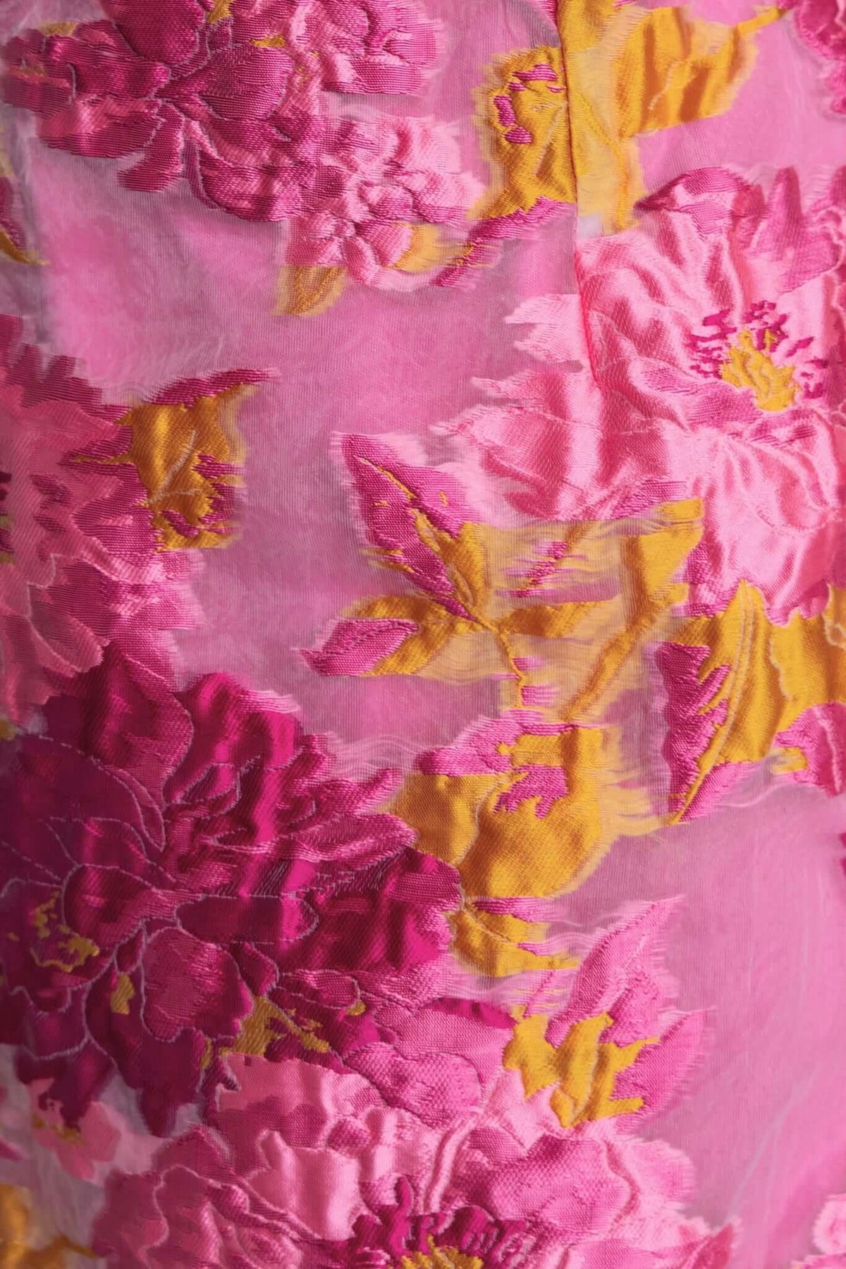 Close-up of vibrant pink and yellow floral embroidery on sheer fabric of Kamryn Maxi Dress.