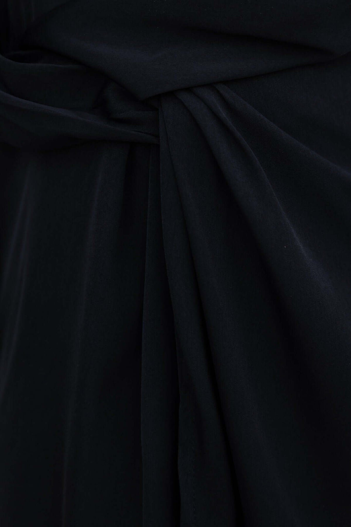 Close-up of soft black fabric of the Miku Dress, showcasing elegant draping and texture.