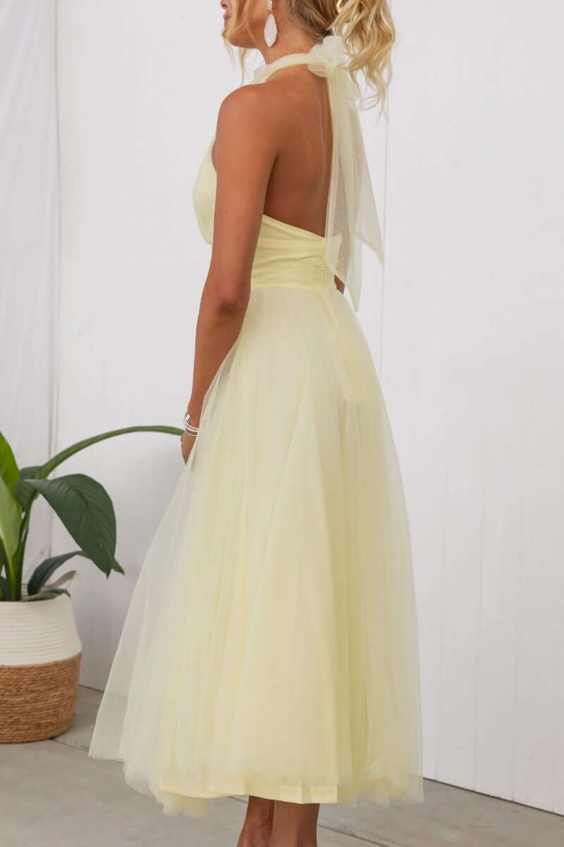 Back view of Love Lane Maxi Dress in light yellow, featuring a halter neckline and tulle skirt.