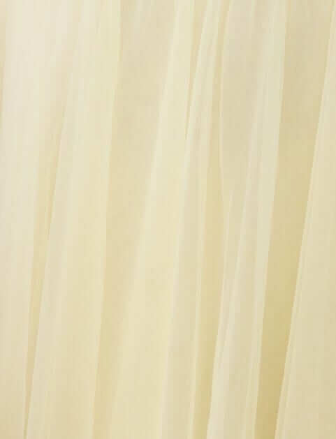 Close-up of soft yellow tulle fabric, showcasing its delicate texture and flowing quality, ideal for a maxi dress.