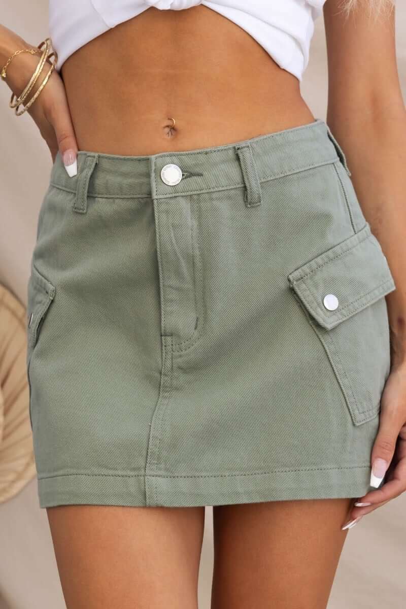 Green cargo style denim skirt with pockets, featuring a stylish and effortless look, perfect for casual outfits.