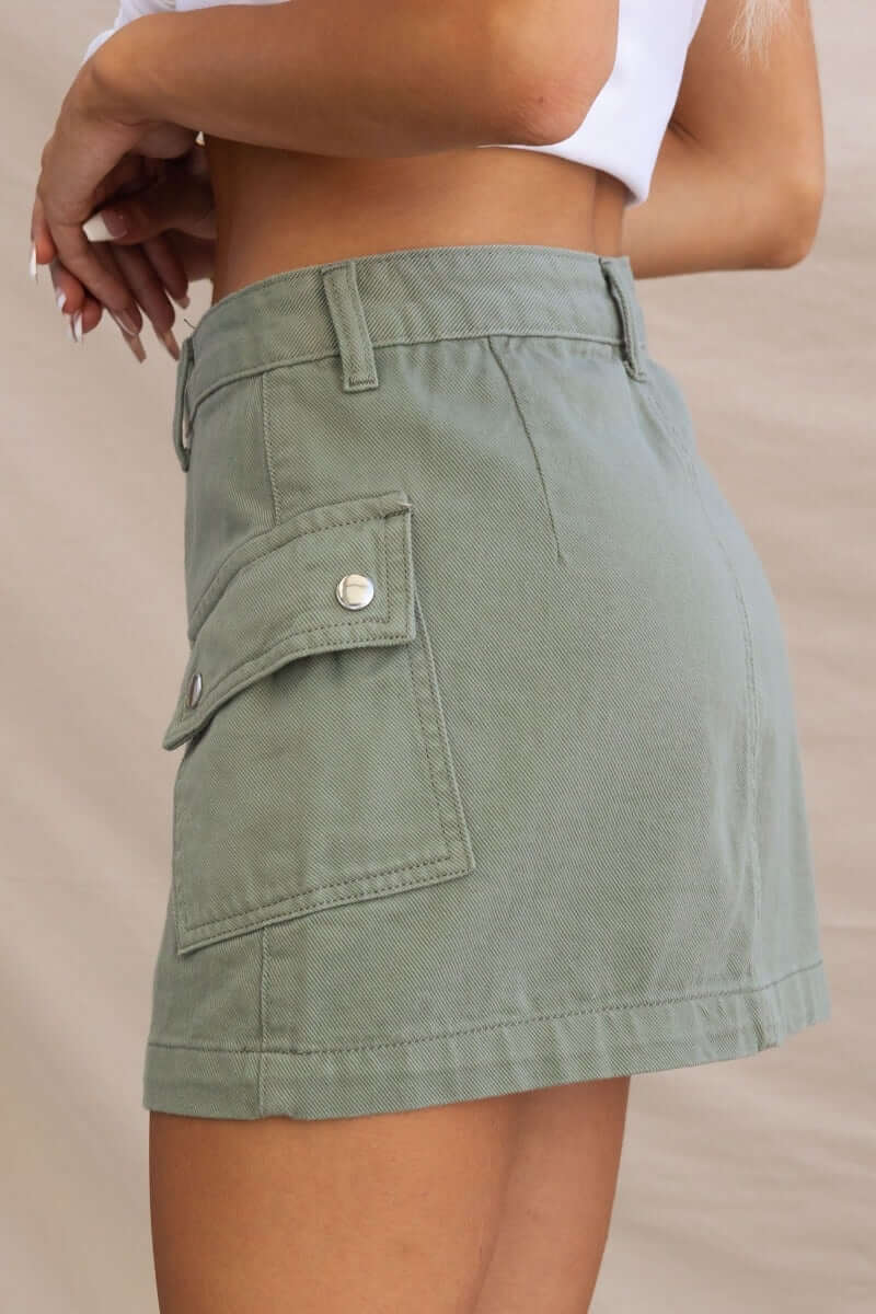 Cargo style denim skirt with pockets, showcasing a fitted silhouette in a stylish green hue.