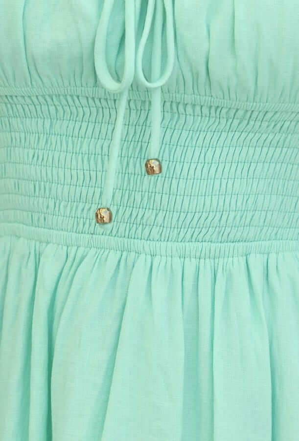 Close-up of Love In Motion Dress in mint green, featuring elastic waistband and tie detail.