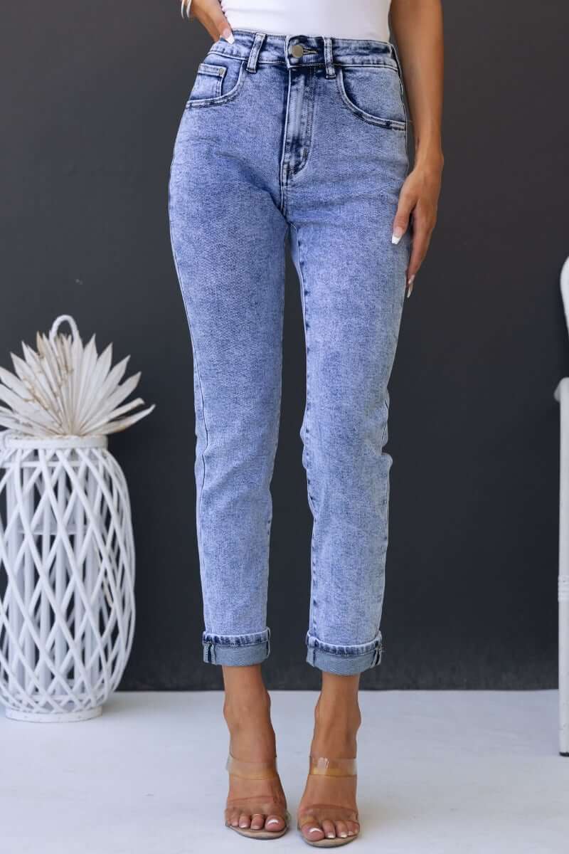 Model wearing Hush Mom Jeans in light wash denim, featuring a mid-high waist and rolled cuffs.