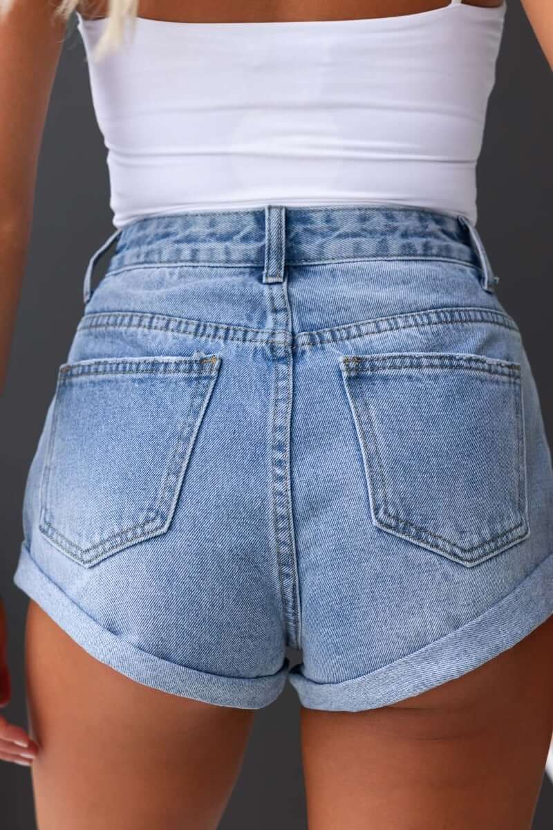 Back view of Kim Denim Shorts featuring a mid-high waist, front and back pockets, and rolled hem.