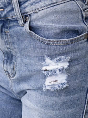 Close-up of Mecka Jeans showing distressed rips and mid-high waist fit, perfect for a stylish casual look.