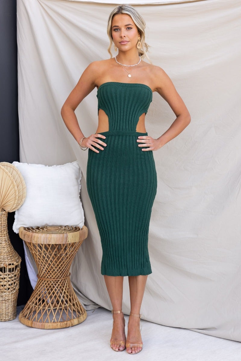 Model wearing Stassie Midi Dress, a strapless green ribbed knit with cut-out at waist and back split.