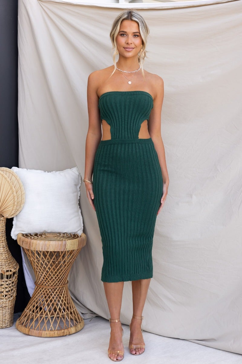 Stassie Midi Dress in dark green, ribbed knit, strapless with cut-out waist and back split, worn by model.