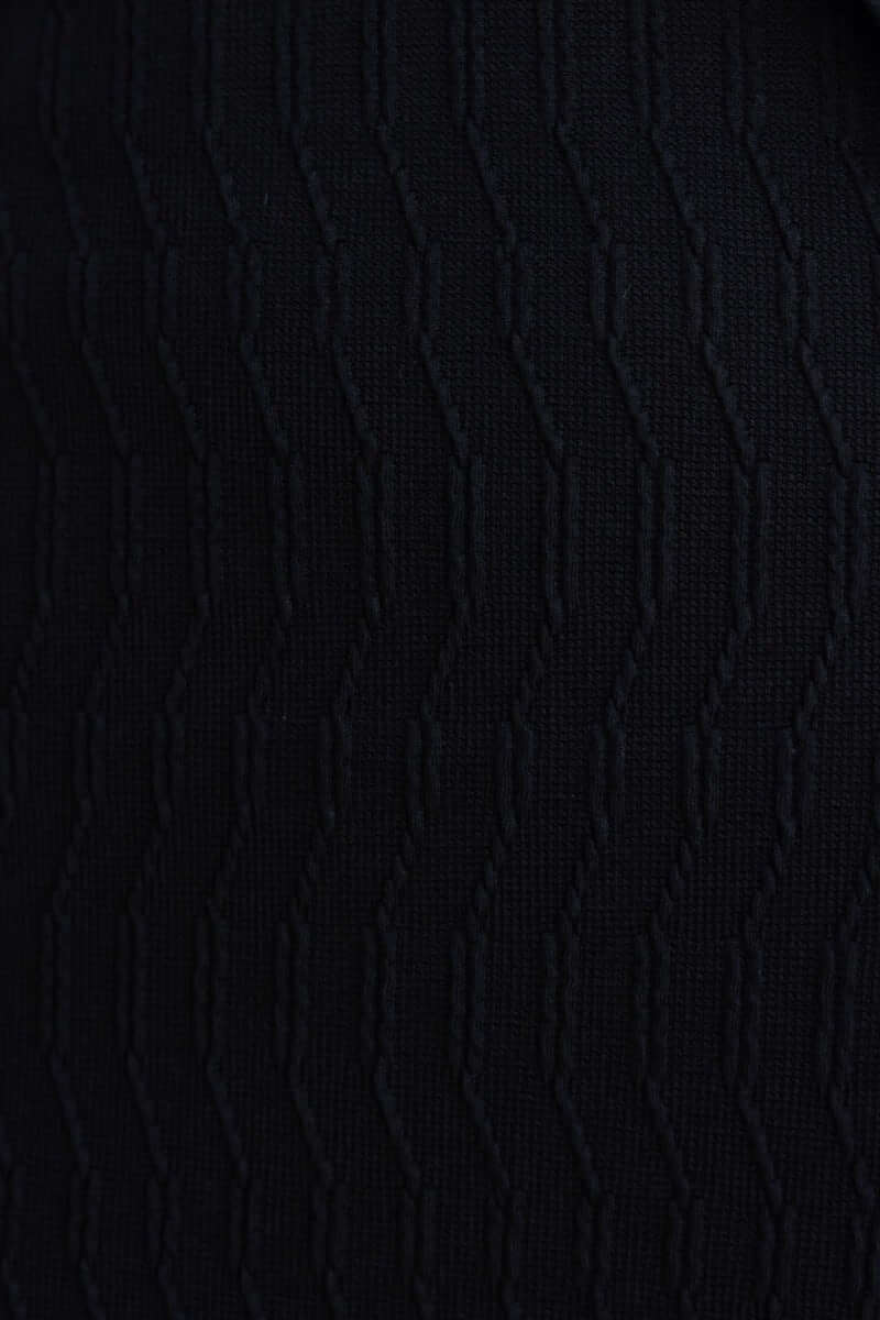 Close-up view of the black textured fabric of the Eyona Midi Dress featuring wavy pattern.