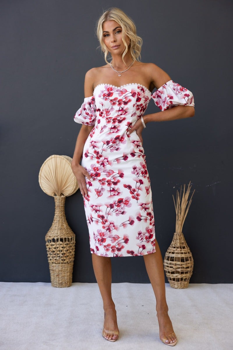 Floral print off-shoulder midi dress with elastic fittings and side split, styled with natural decor.