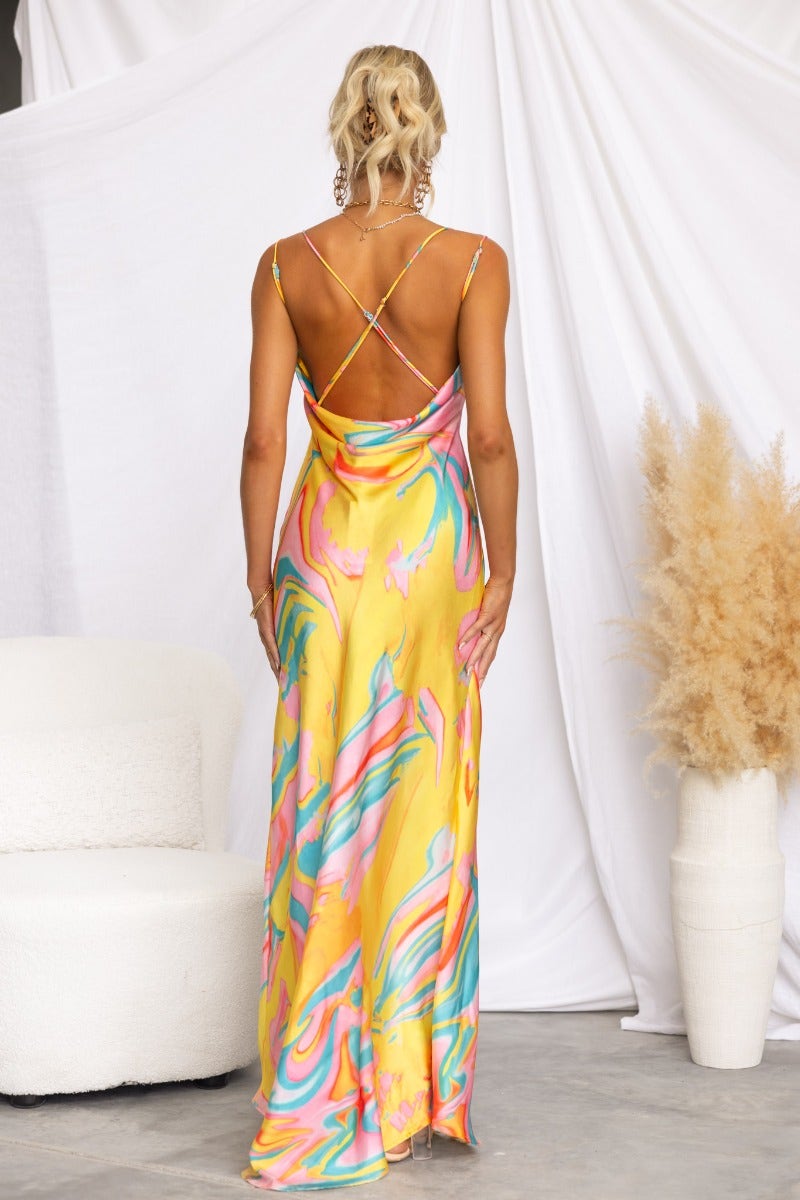Back view of Visionary Maxi Dress featuring bright colors, cowl neckline, and adjustable straps, displayed in a stylish setting.