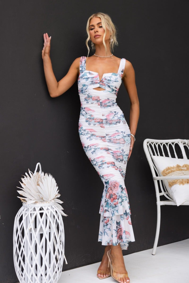 Model wearing Zachia Maxi Dress, a white floral mesh overlay maxi dress with ruffle hem and V-wire bust detail.