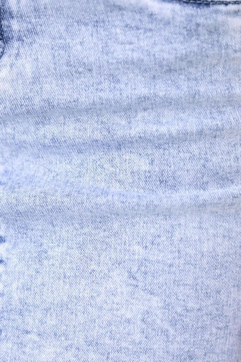Close-up of acid wash denim texture, highlighting the faded blue fabric of a Bonny denim skirt.